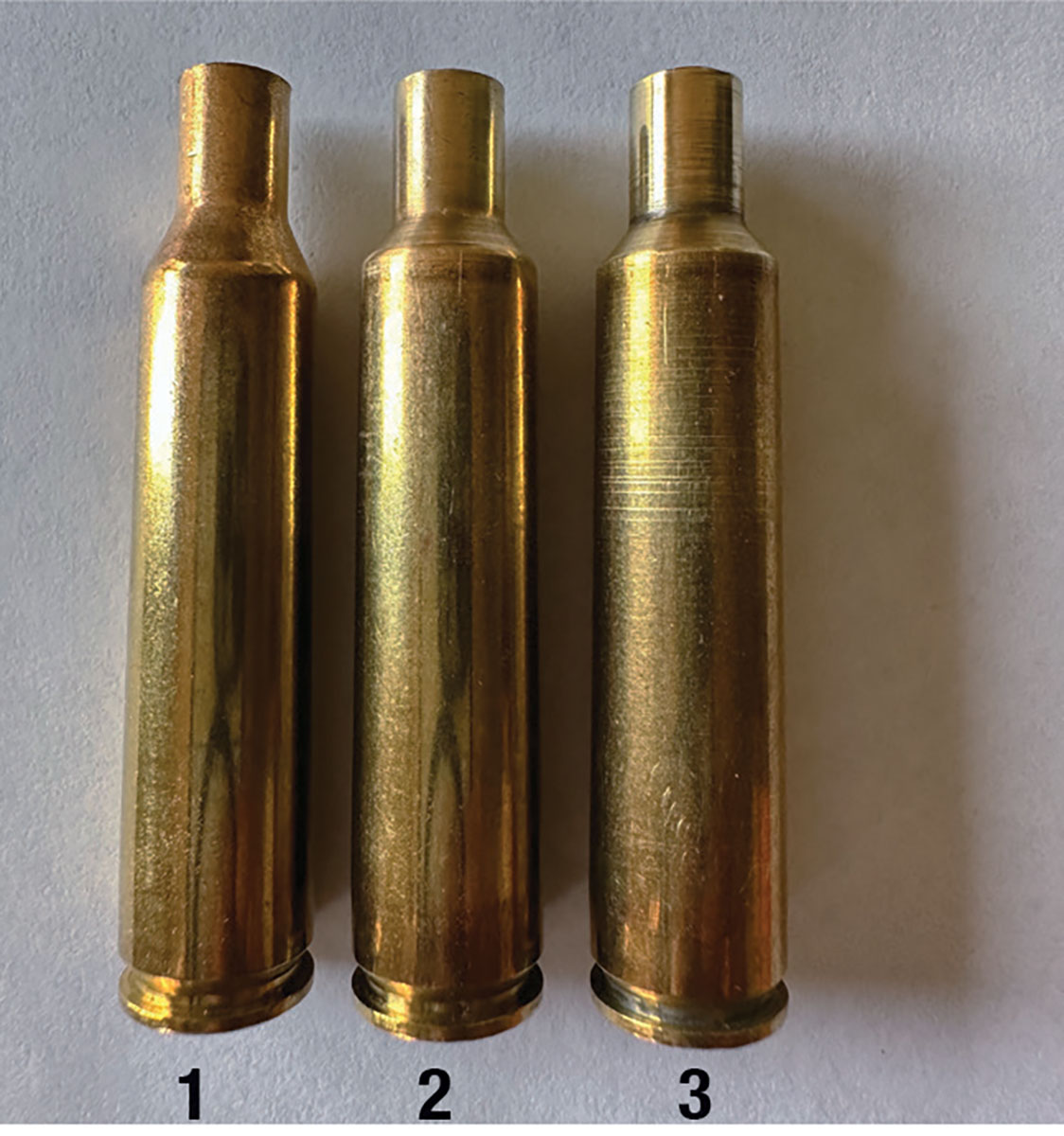 (1) A virgin, unfired 6mm Remington case case, (2) a once-fired 6mm Remington AI and (3) a 6mm Remington AI case that has been fired three times.